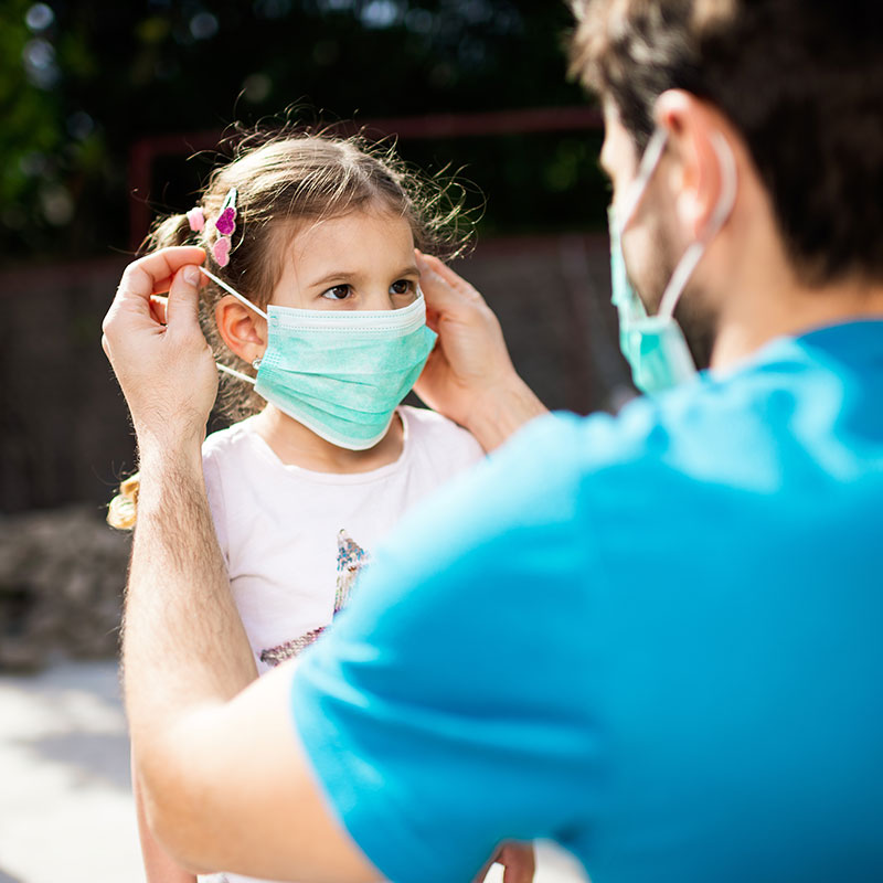 Dad applying Mask to Child