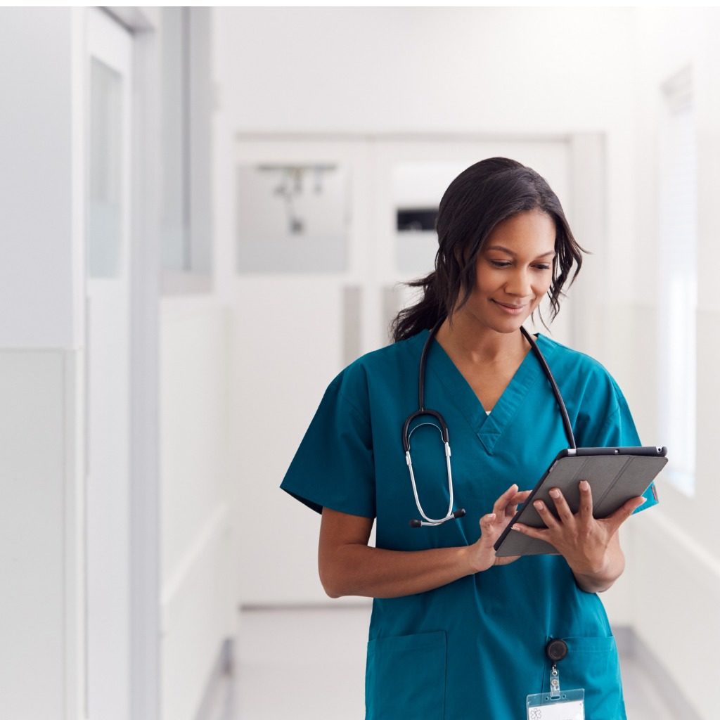 female-doctor-wearing-scrubs-in-hospital-corridor-using-digital-picture-id1205548238